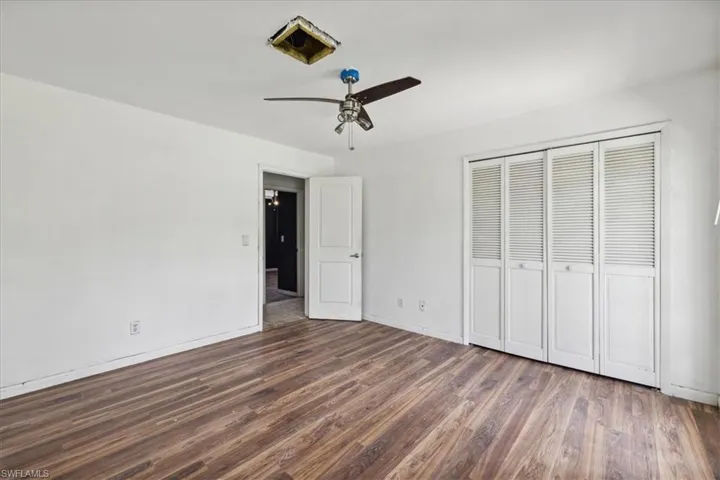 Unfurnished bedroom featuring hardwood / wood-style floors, ceiling fan, and a closet