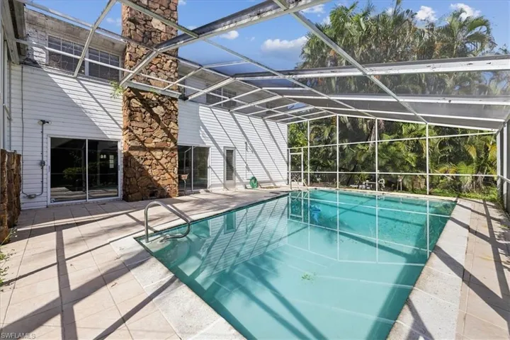 View of pool with enclosure and a patio