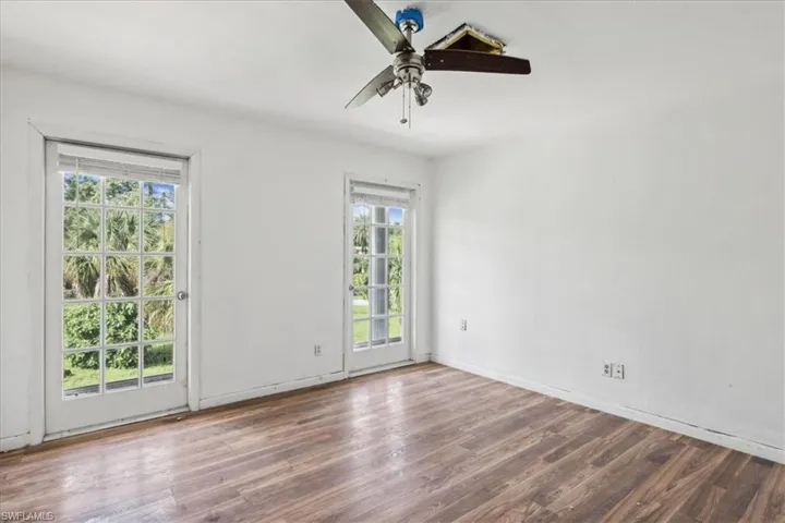 Empty room featuring hardwood / wood-style flooring, a healthy amount of sunlight, and ceiling fan