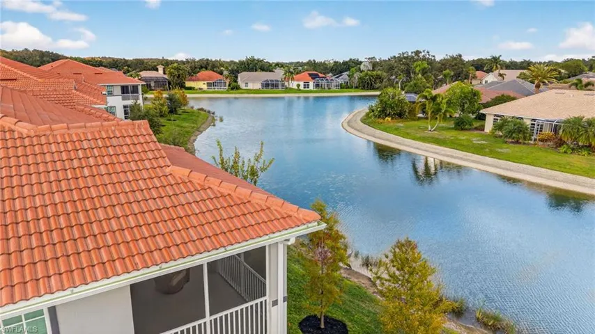 Terracotta tile roofing, screened-in lanai, and waterfront positioning overlooking a large retention pond