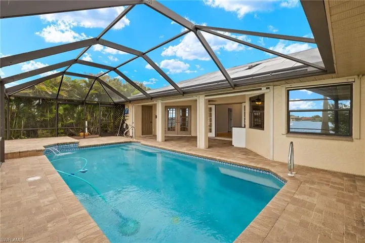 Outdoor pool featuring a lanai, a sunroom, french doors, and a patio
