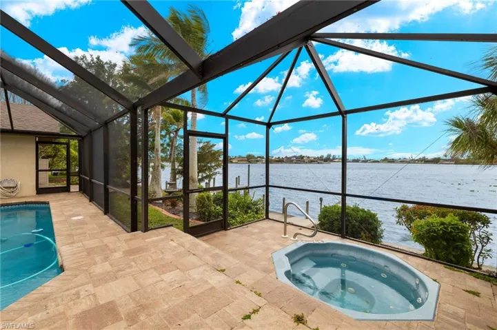 Swimming pool with a sunroom, an in-ground hot tub, and glass enclosure