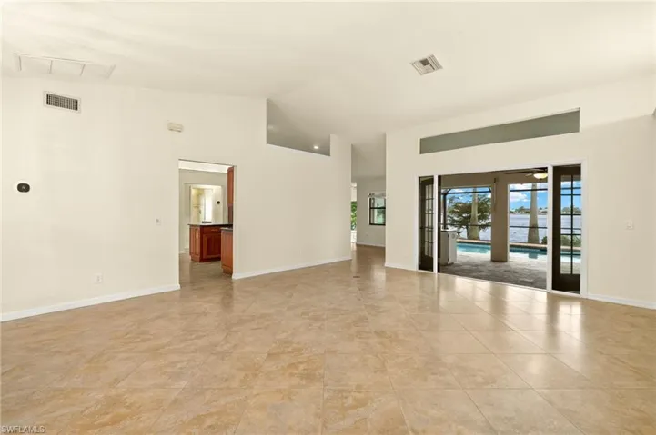 Empty room featuring lofted ceiling and baseboards