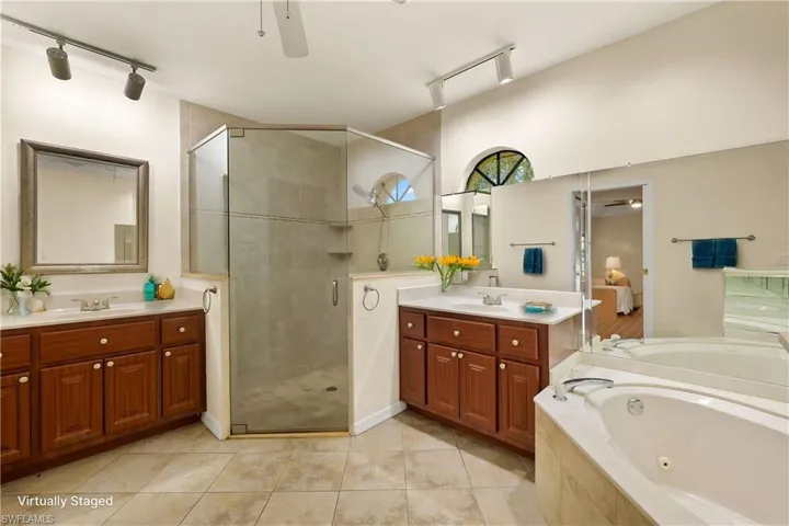 Bathroom with a ceiling fan, rail lighting, and a shower stall