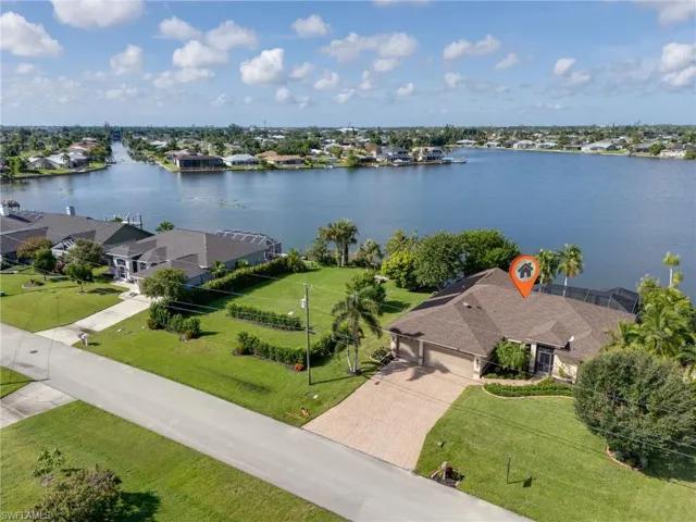 Aerial perspective of suburban area featuring a nearby body of water