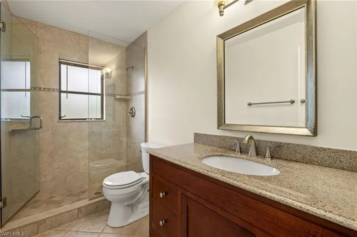 Bathroom with vanity, a shower stall, and light tile patterned floors