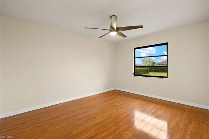 Empty room with light wood-style flooring and ceiling fan