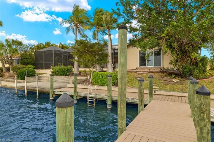 Dock area featuring a sunroom, a lanai, and a water view