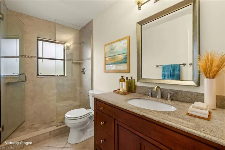 Full bathroom featuring vanity, a shower stall, and light tile patterned floors