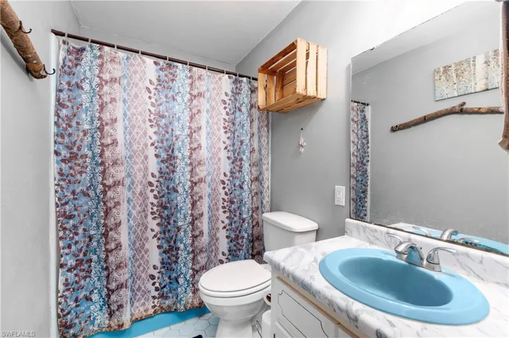 Bathroom featuring tile patterned flooring, toilet, and vanity