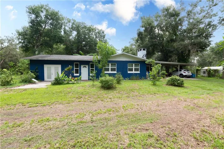 View of front of property featuring a carport and a front yard