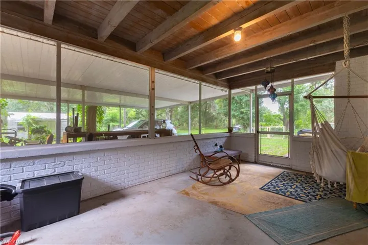 Sunroom / solarium with beamed ceiling and wooden ceiling