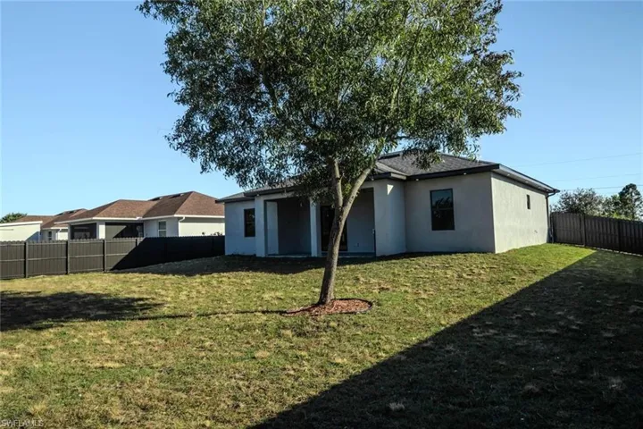 Back of property featuring a fenced backyard and stucco siding