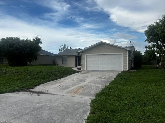 Ranch-style house featuring a garage and a front yard