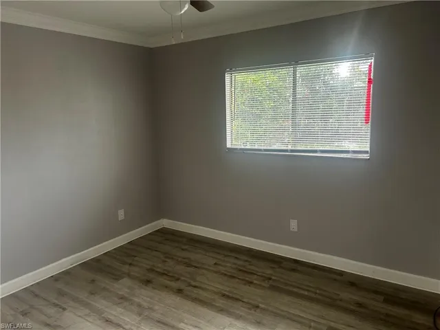 Unfurnished room featuring ceiling fan, hardwood / wood-style flooring, and ornamental molding