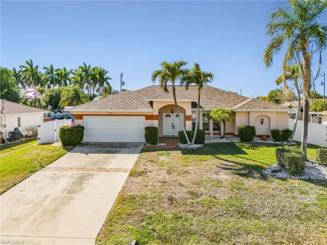 Ranch-style home with driveway, an attached garage, and stucco siding