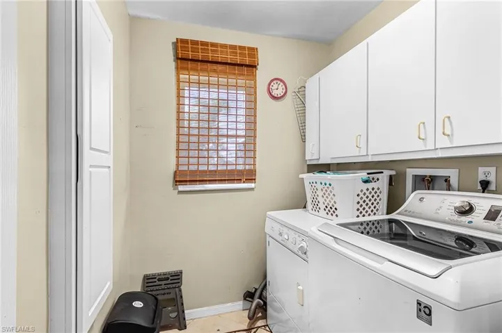 Laundry area featuring cabinet space and washer and clothes dryer