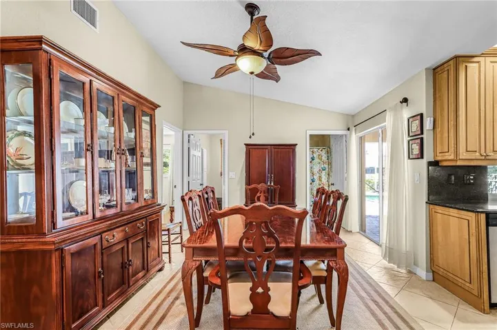 Dining room featuring ceiling fan, lofted ceiling, and light tile patterned floors