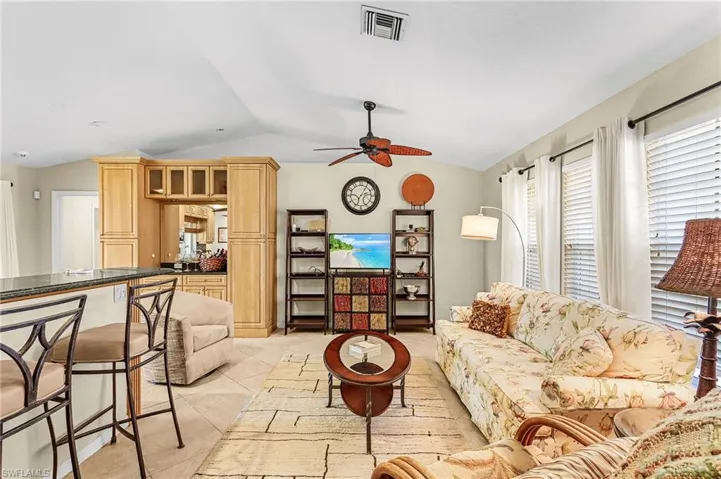 Living room with light tile patterned floors and a ceiling fan