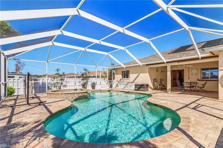 Relaxing pool / spa with a sunroom, a patio, and a lanai