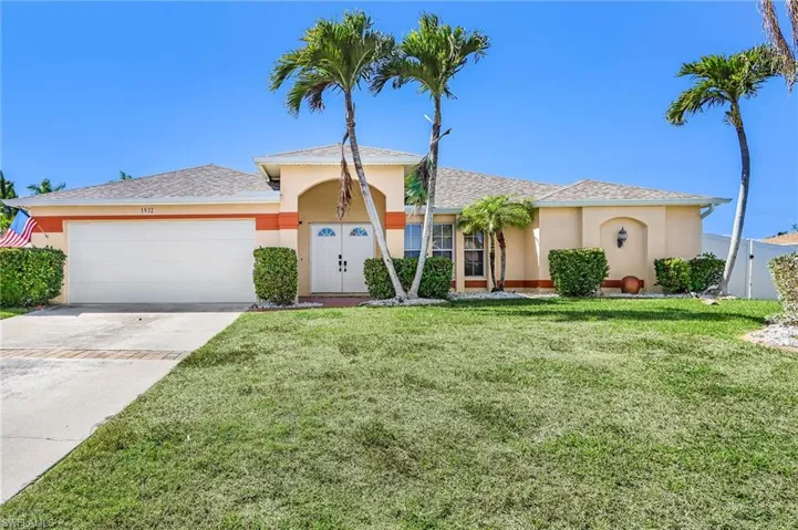 View of front of property with stucco siding, concrete driveway, an attached garage, a front lawn, and a shingled roof
