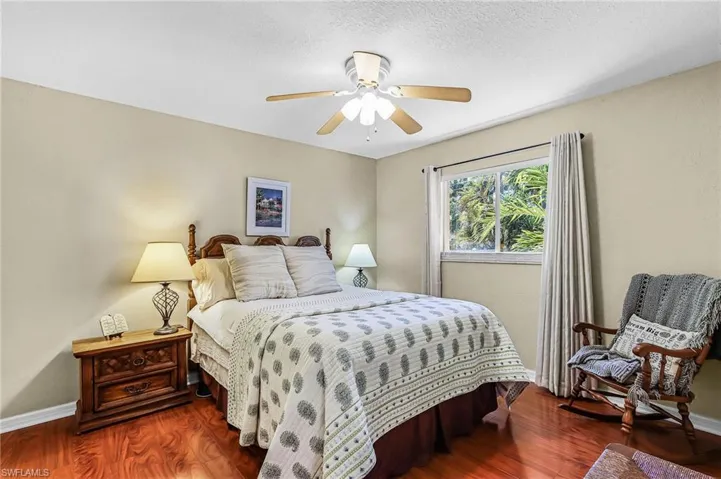 Bedroom featuring dark wood-type flooring, ceiling fan, and a textured ceiling