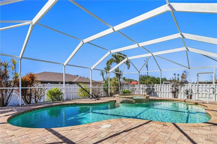 Combined pool / hot tub with a fenced backyard, glass enclosure, and a sunroom