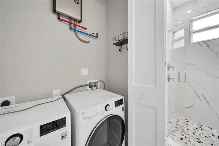Laundry area featuring water heater and separate washer and dryer