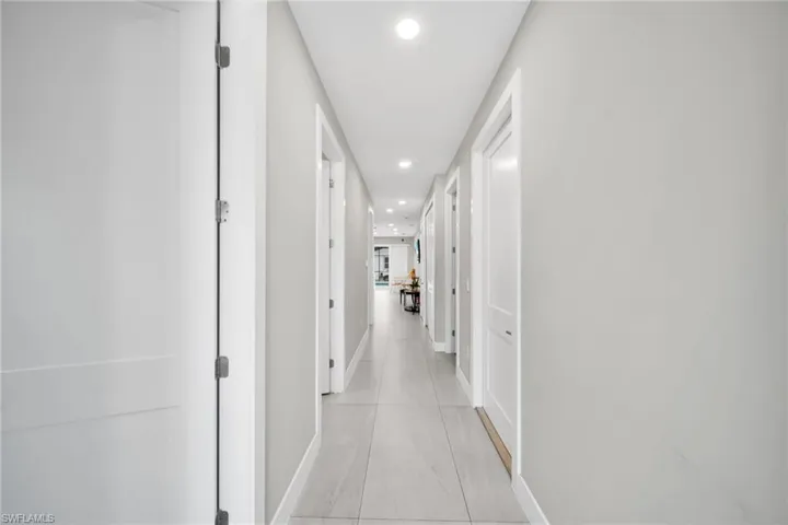 Hallway with recessed lighting and baseboards