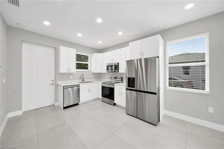 Kitchen featuring stainless steel appliances, white cabinets, recessed lighting, and light tile patterned floors