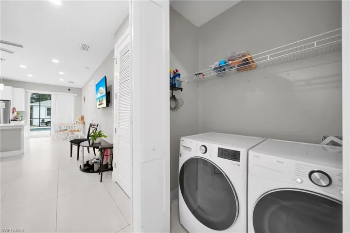 Laundry area with washer and dryer, recessed lighting, and light tile patterned floors