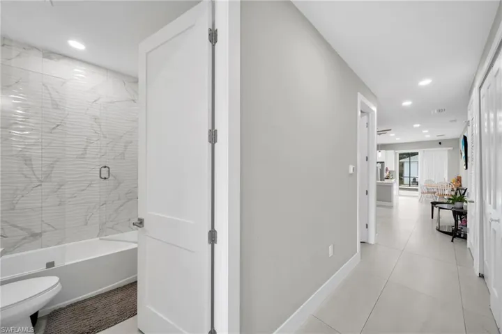 Hallway featuring recessed lighting and light tile patterned flooring