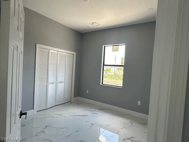 Unfurnished bedroom featuring a closet and light tile floors