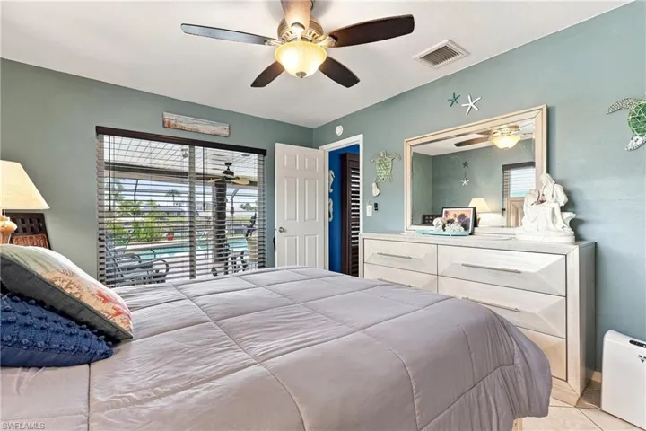 Sliding glass doors with horizontal blinds, overhead ceiling fan, interior paneled door, and a built-in closet with louvered doors