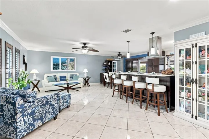Open-concept living area with tile flooring and crown molding