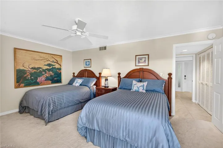 This room features carpeted flooring, a ceiling fan, and crown molding
