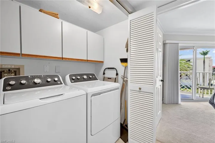 The laundry area features white cabinets with wood trim, offering storage solutions