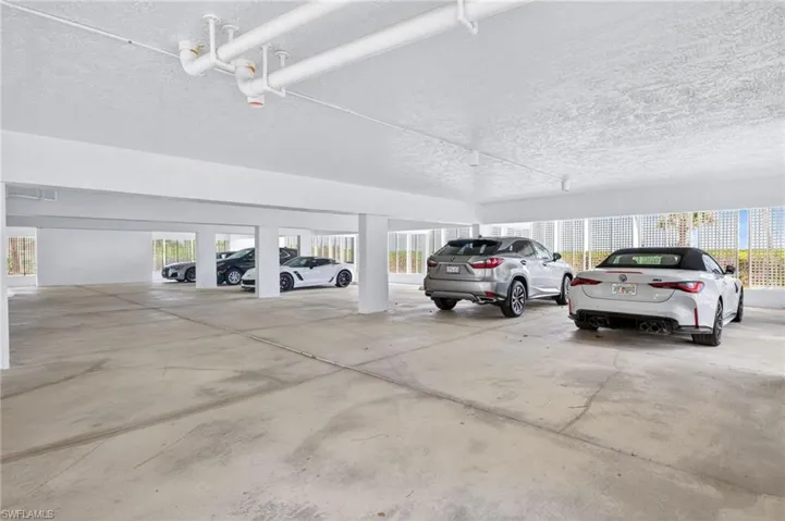 The property features a spacious covered parking area with a concrete floor and a white ceiling with visible piping
