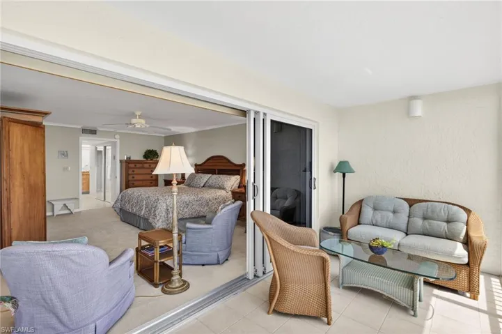 Entrance into Primary Bedroom with light-colored walls and carpeting, a ceiling fan, and a light-colored headboard