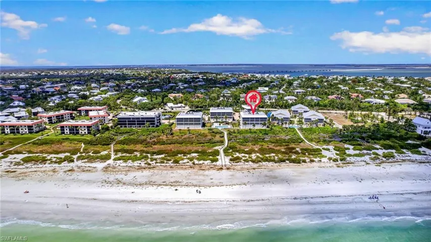 Overhead view of the property, located directly on a beachfront, with visible pathways leading to the sand