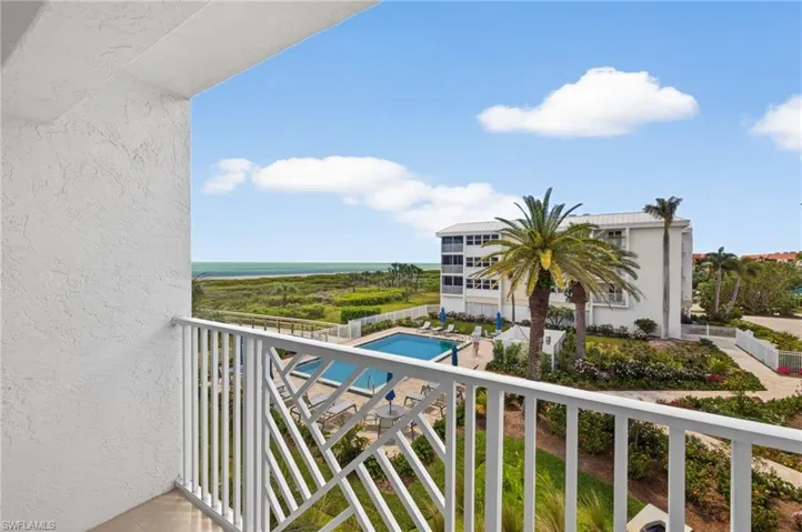 Enjoy views of the ocean, a swimming pool, and tropical landscaping from the property's balcony