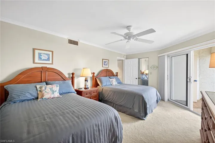 This room features light-colored walls, carpeted flooring, and a ceiling fan