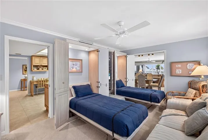 Den featuring two Murphy beds, a ceiling fan, and carpeted flooring