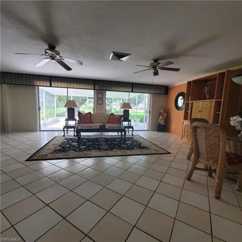 Living area featuring ceiling fan and light tile patterned flooring