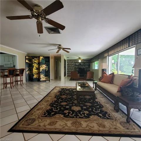 Living room with ceiling fan and light tile patterned flooring