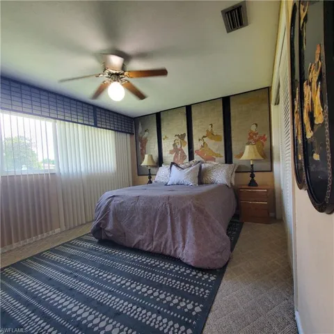 Carpeted bedroom featuring a ceiling fan