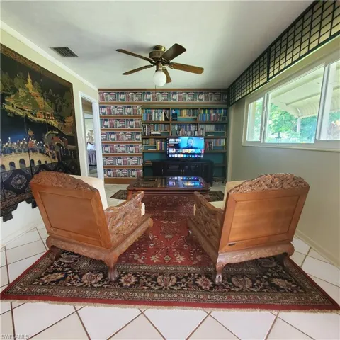 Living area featuring ceiling fan and tile patterned flooring