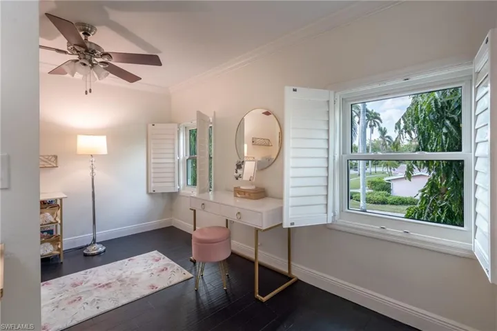 Bathroom with wood finished floors, baseboards, ornamental molding, and ceiling fan
