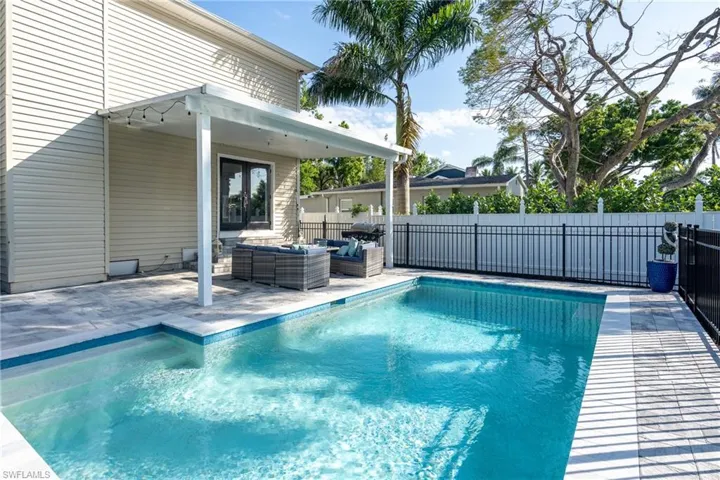 View of pool featuring an outdoor living space, a fenced in pool, a patio, and fence