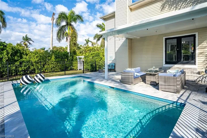 View of swimming pool featuring a patio area, an outdoor hangout area, a fenced in pool, and fence